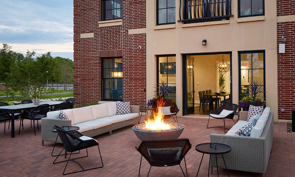 couches and chairs surrounding a fire pit outside the Kelmscott Park clubhouse