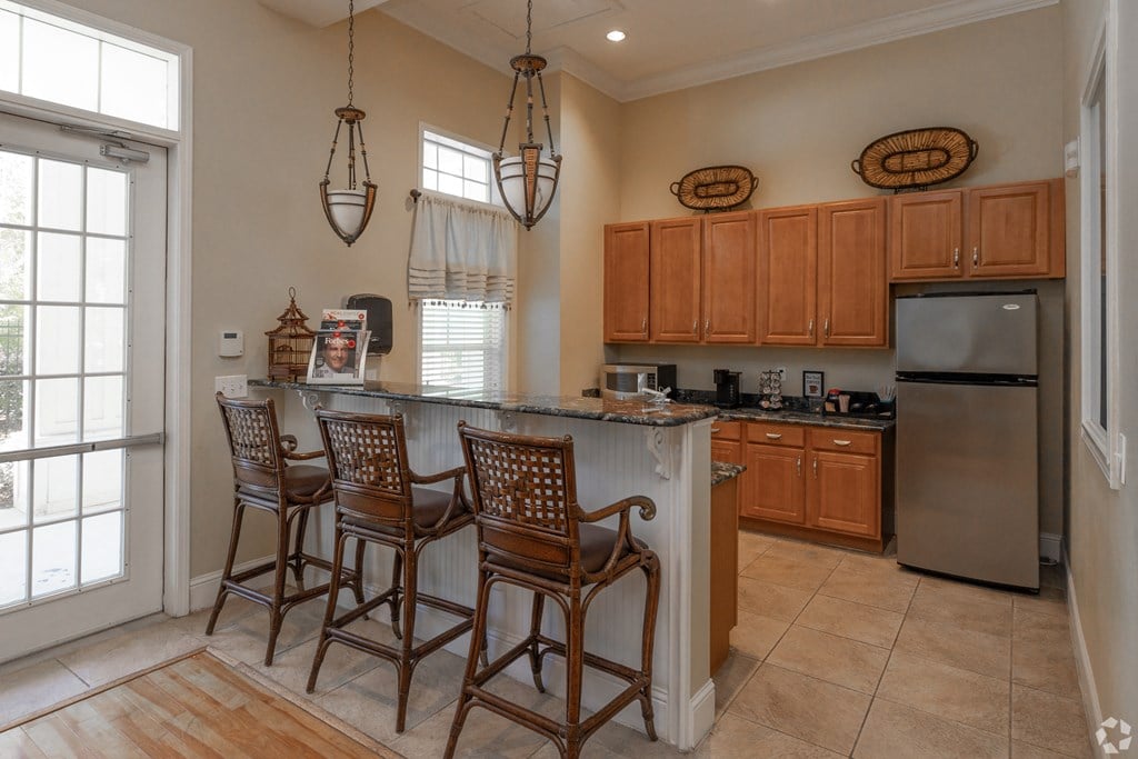 A kitchen with wooden cabinets and a bar area.