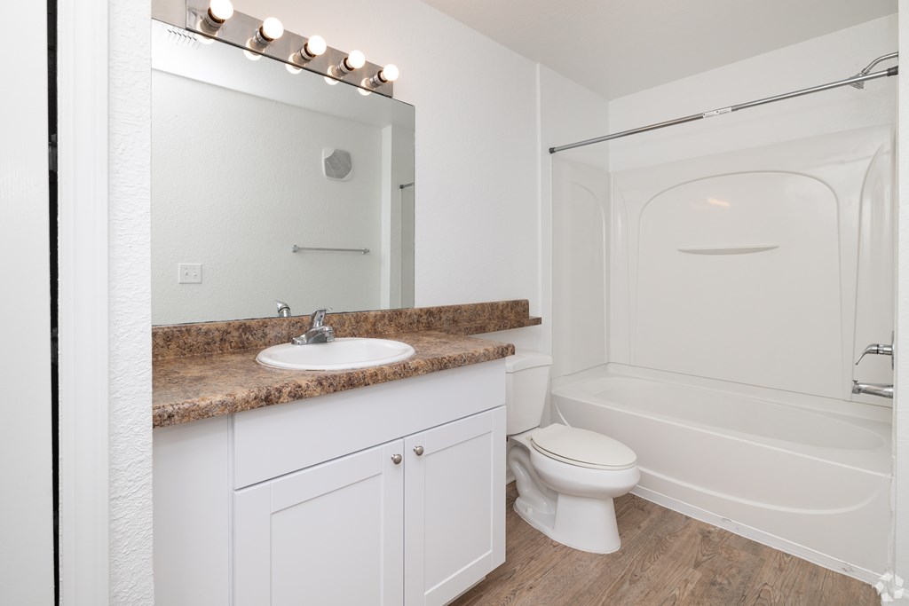 A white bathroom with a sink, toilet, and bathtub.