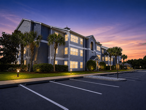 A large building with a parking lot in front of it.