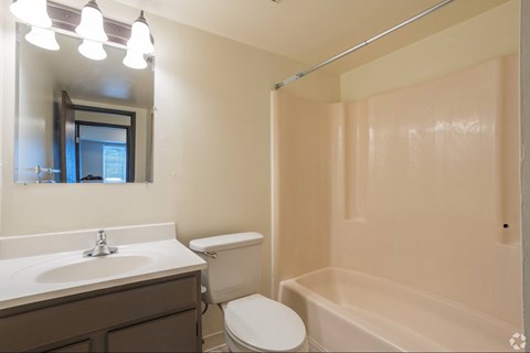 A bathroom with a toilet, sink, and bathtub.