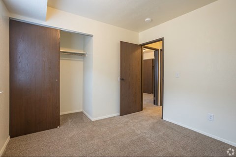 A room with a brown door and a white wall.
