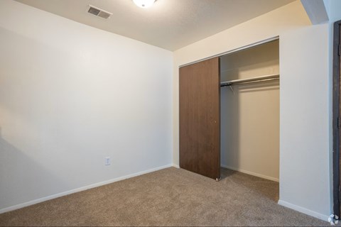 A room with a brown door and carpeted floor.