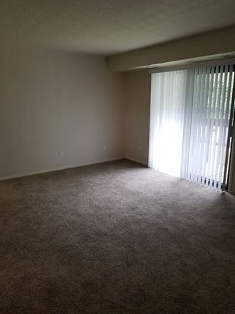 an empty living room with a sliding glass door