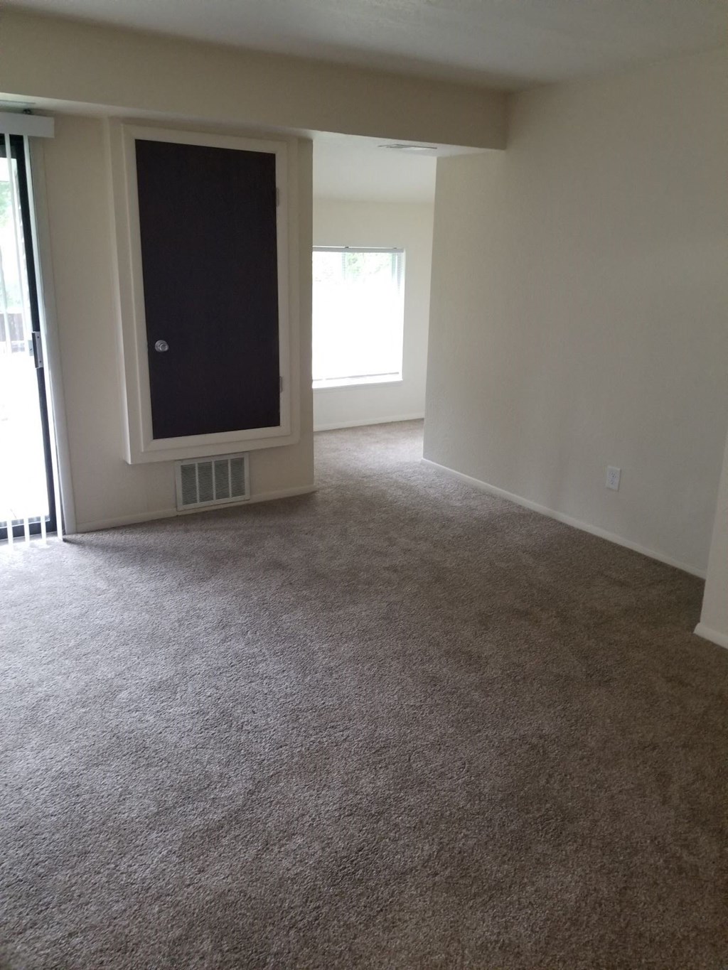 an empty living room with a tv in the corner