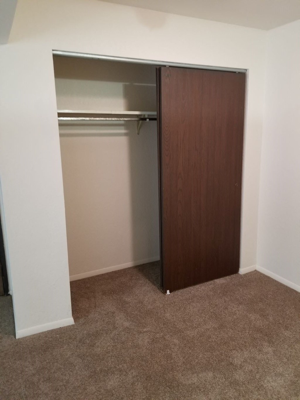 an empty closet in a room with a carpet