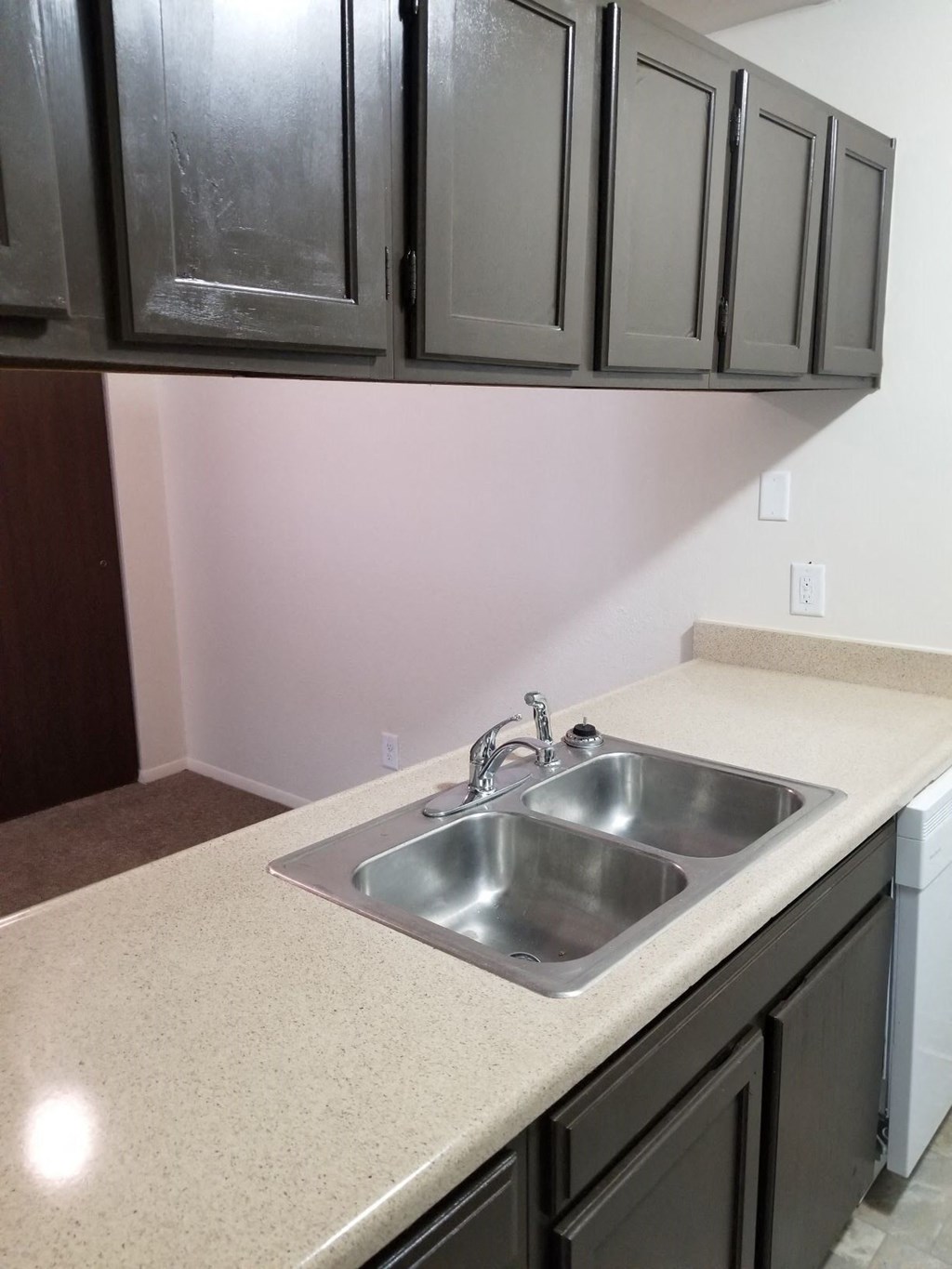 a kitchen with a stainless steel sink and black cabinets