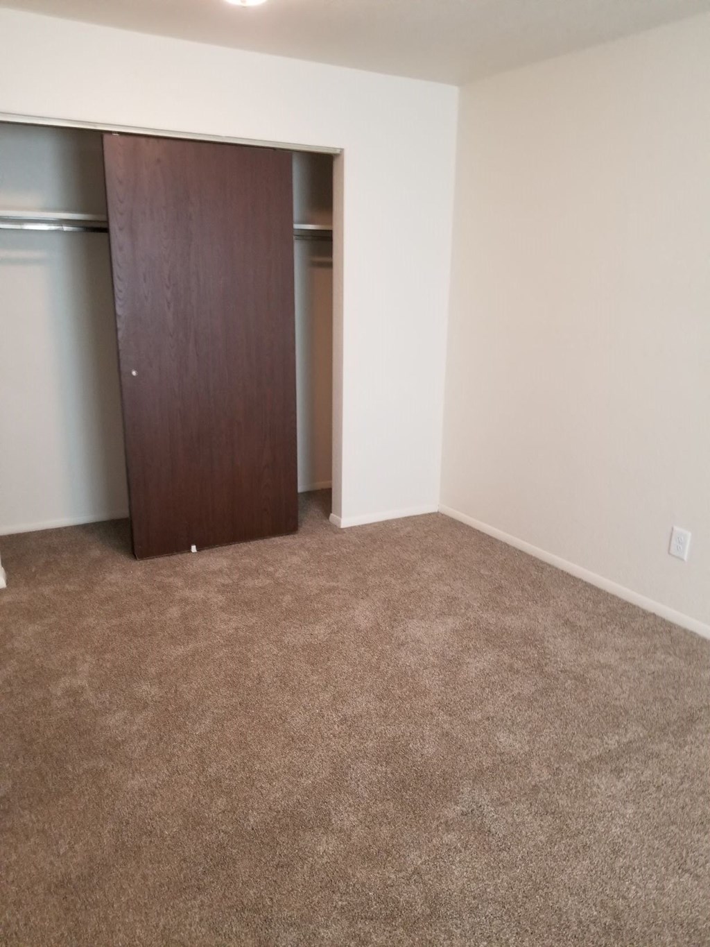 an empty living room with a door to a closet