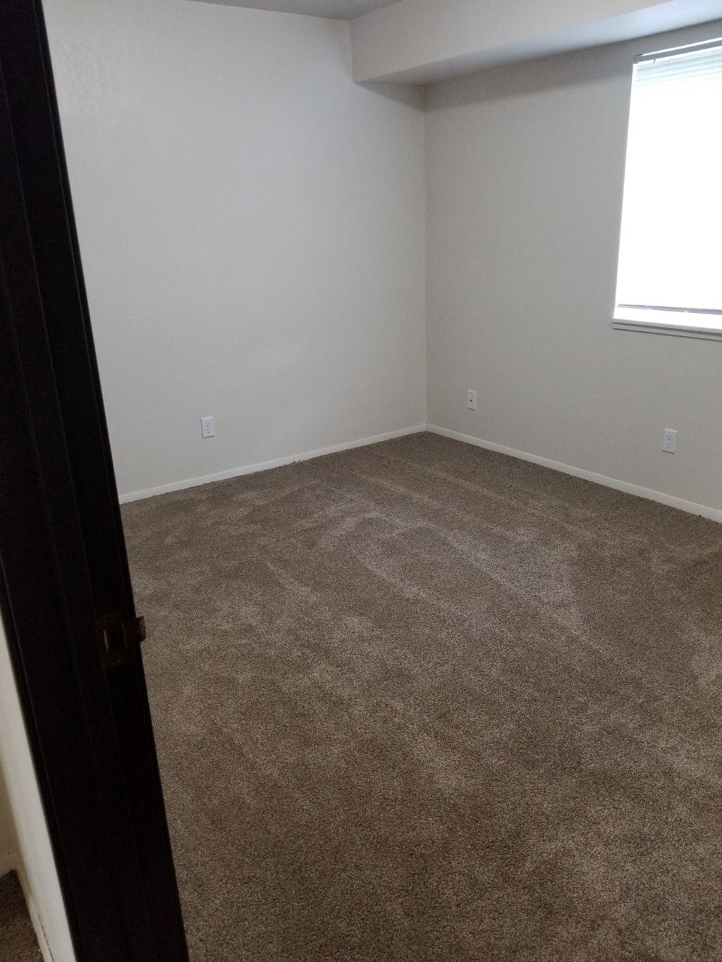 an empty room with carpet and a window