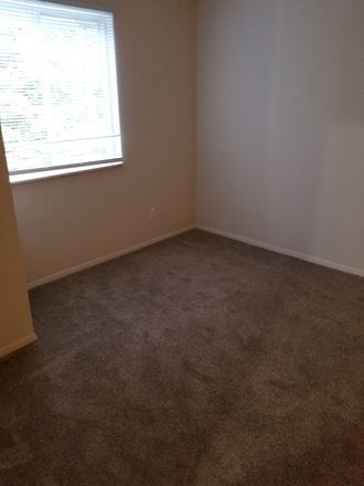a room with a carpeted floor and a window