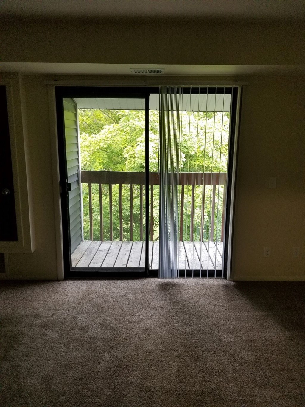 a living room with a balcony and a sliding glass door