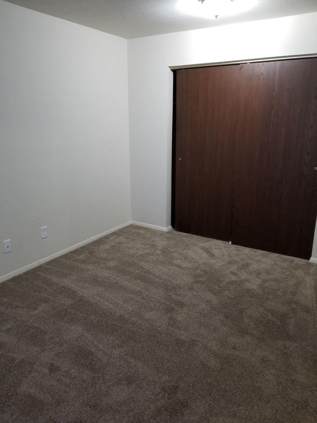 a room with a carpeted floor and a wooden door