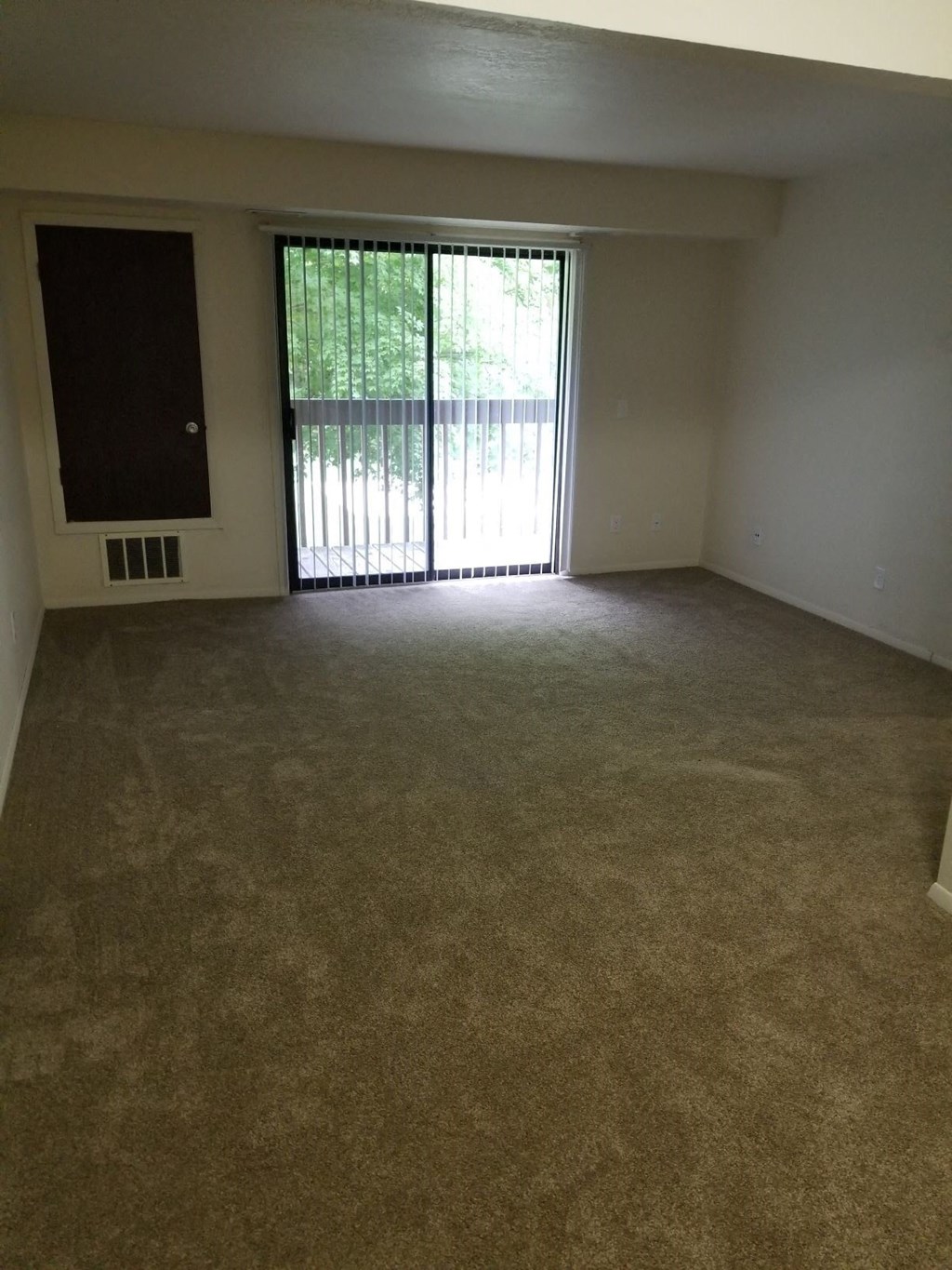 an empty living room with a sliding glass door