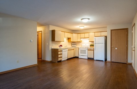 A kitchen with white appliances and wooden cabinets.