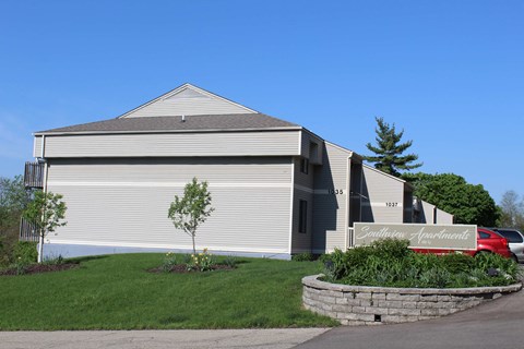 a view of the front of a building with a stone retaining wall