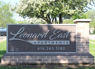 a sign for lenard east apartments in front of a tree