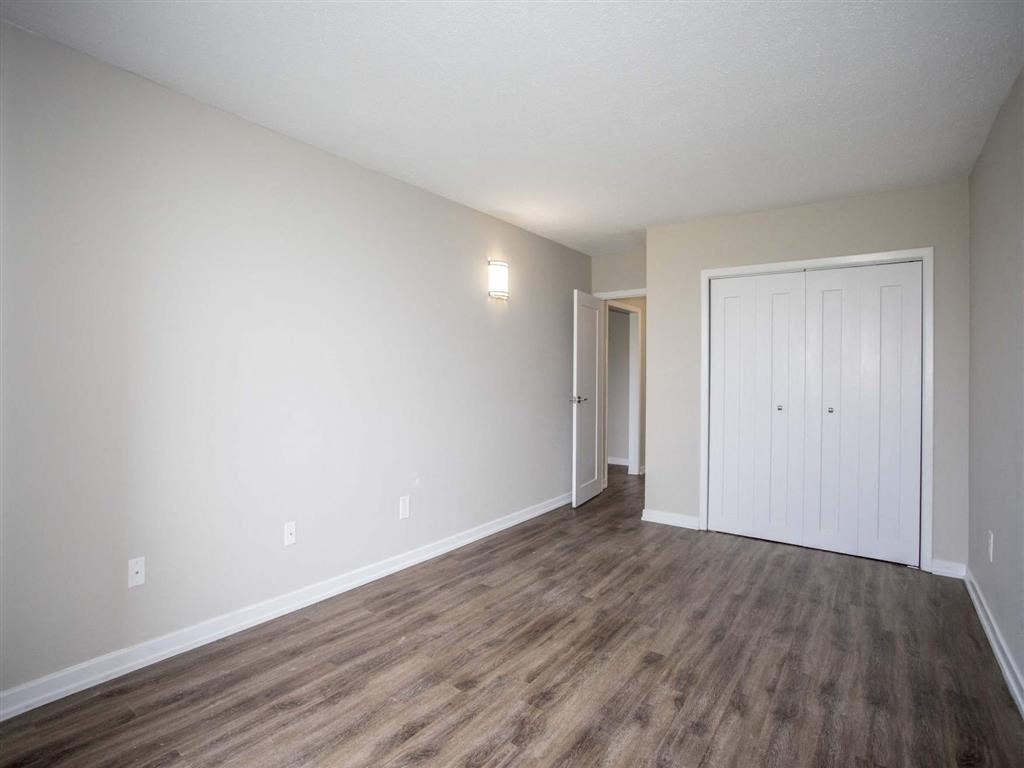 an empty living room with white walls and wood flooring
