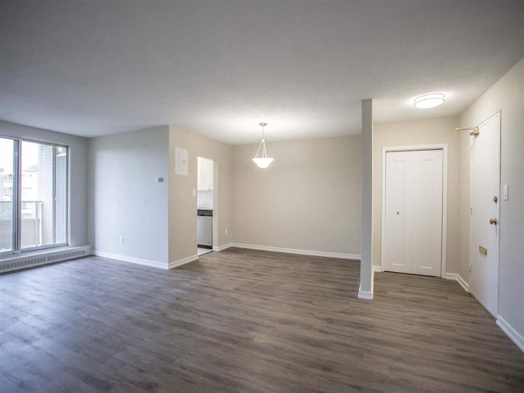 an empty living room with wood floors and a window