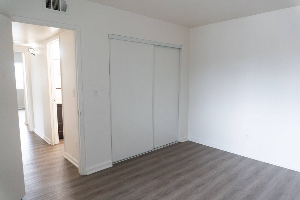 an empty living room with white walls and wood floors