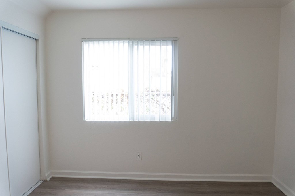 an empty room with a window and a door