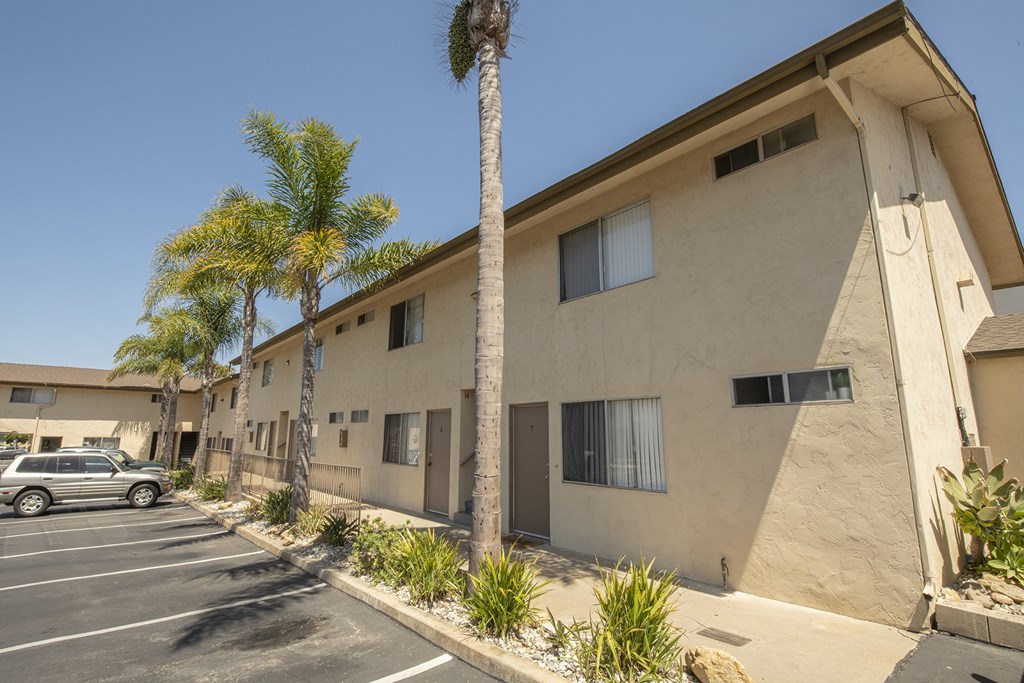an apartment building with palm trees and a parking lot at Casa Sol Apartments, California