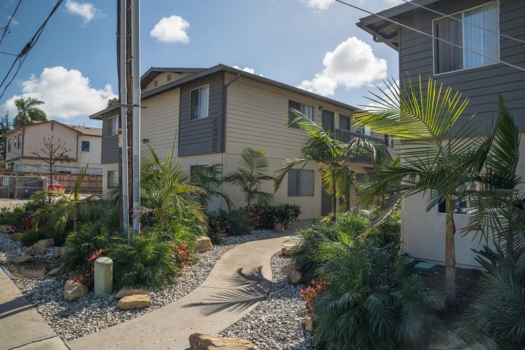 a home with a pathway and palm trees in front of it at Casa Sol Apartments, Imperial Beach, 91932