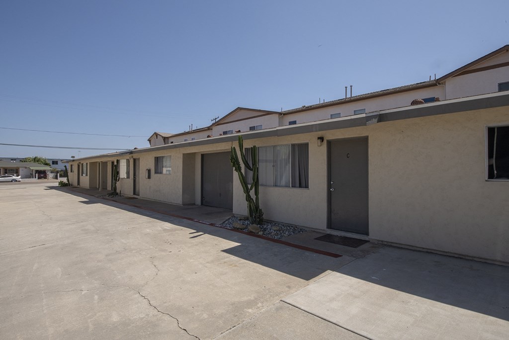 an exterior view of a building with an empty parking lot at Casa Sol Apartments, Imperial Beach, CA