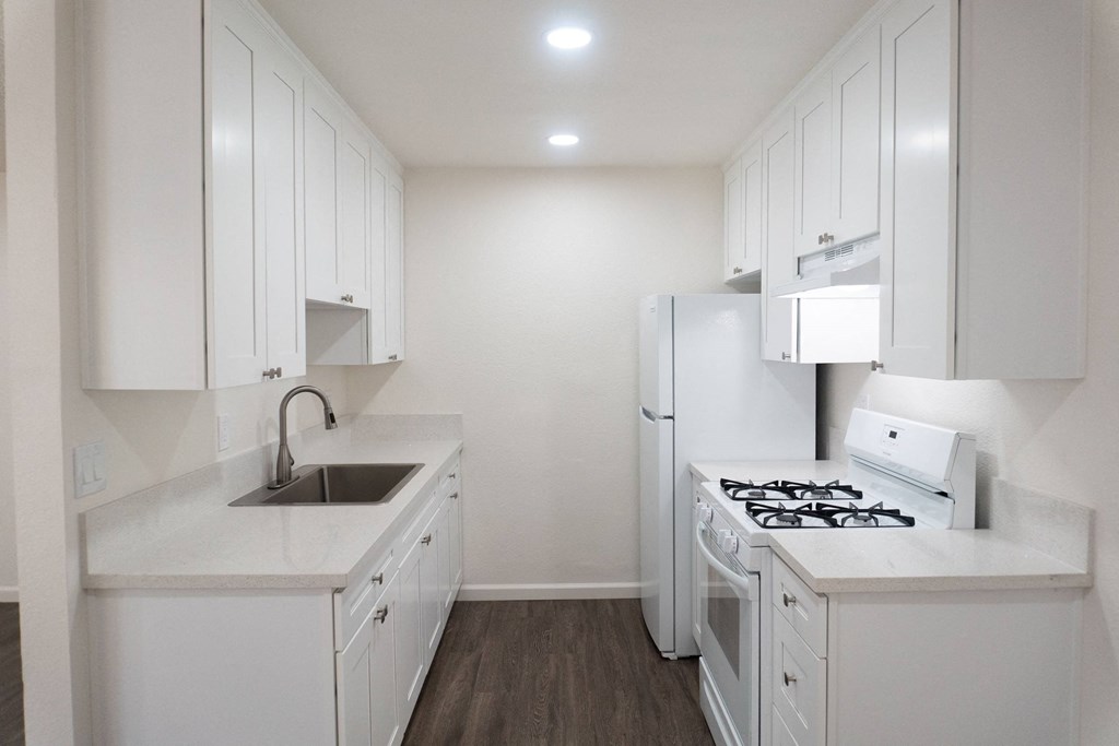 a kitchen with white cabinets and a white stove and refrigerator at Casa Sol Apartments, Imperial Beach, CA 91932
