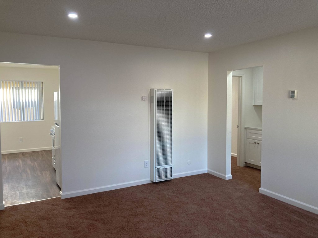 an empty living room with a heater in the corner at Casa Sol Apartments, California, 91932