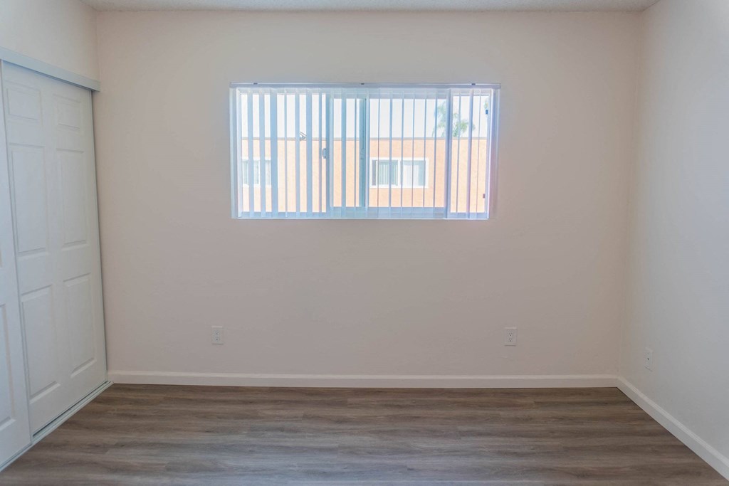 a living room with a window and a wooden floor at Casa Victoria Apartments, Chula Vista, California