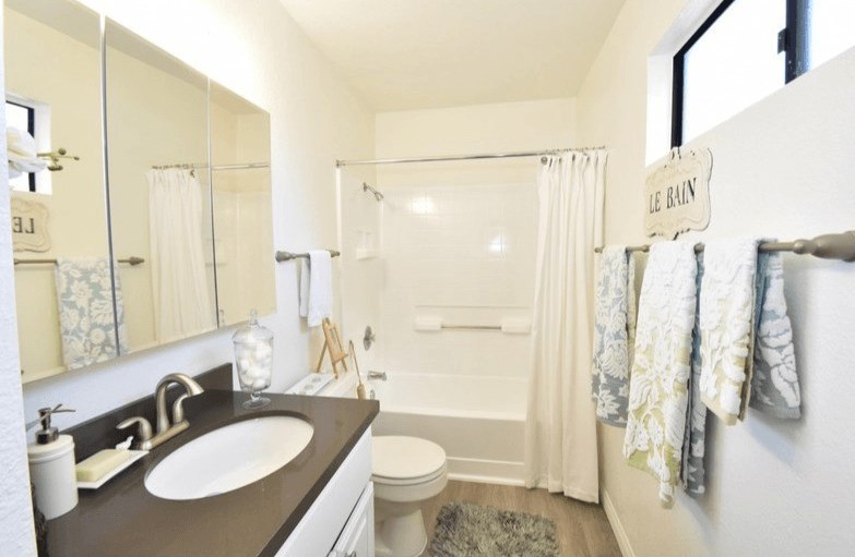 a bathroom with a sink and a toilet and a shower at Sycamore Hills Village Apartments, California