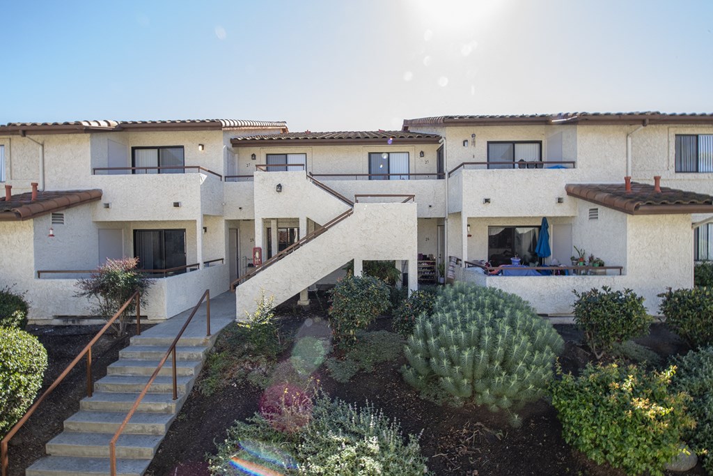 a view of the exterior of a building with stairs and a garden at Sycamore Hills Village Apartments, Vista, CA, 92081