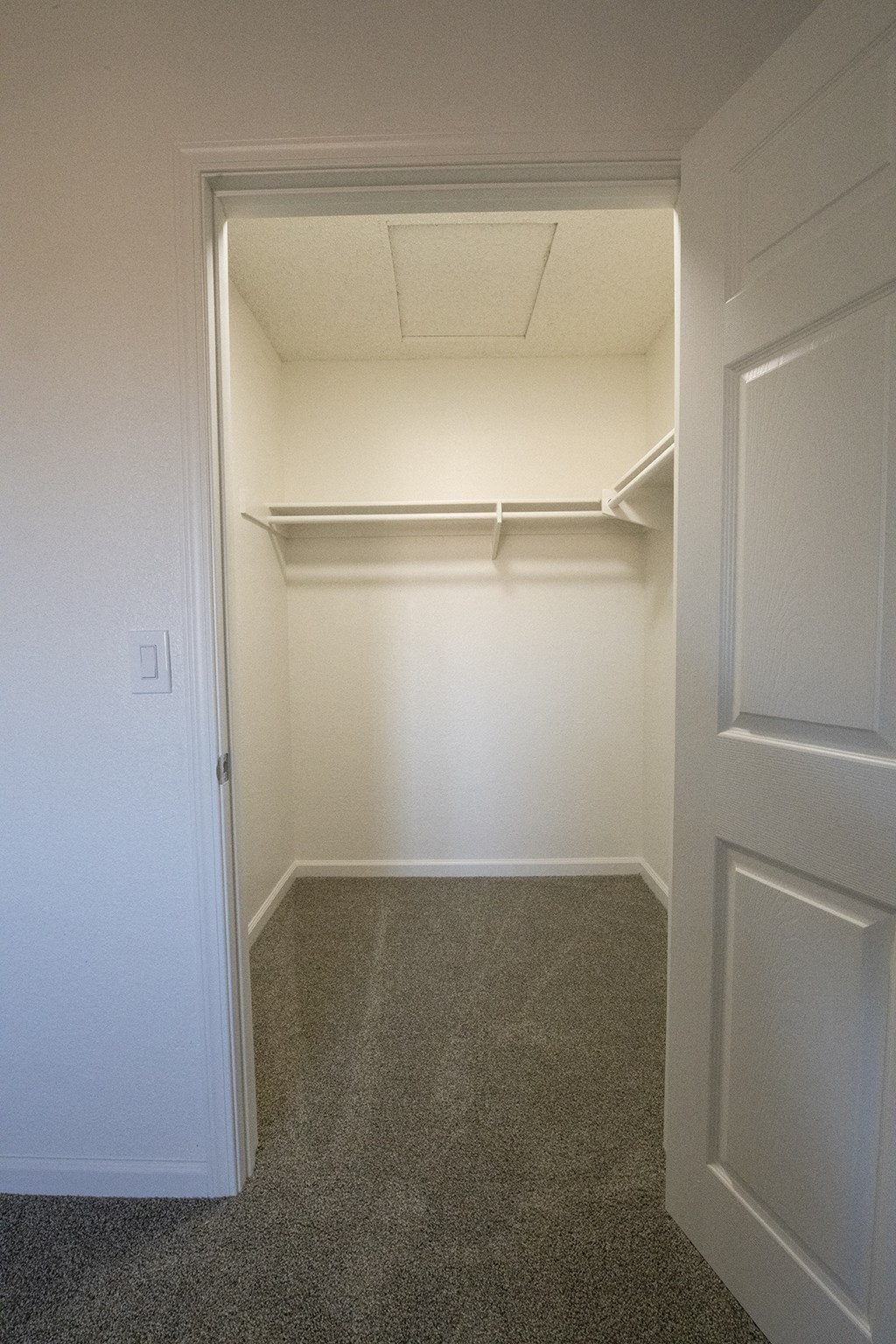 a walk in closet in a home with white walls and carpet at Sycamore Hills Village Apartments, Vista, CA, 92081