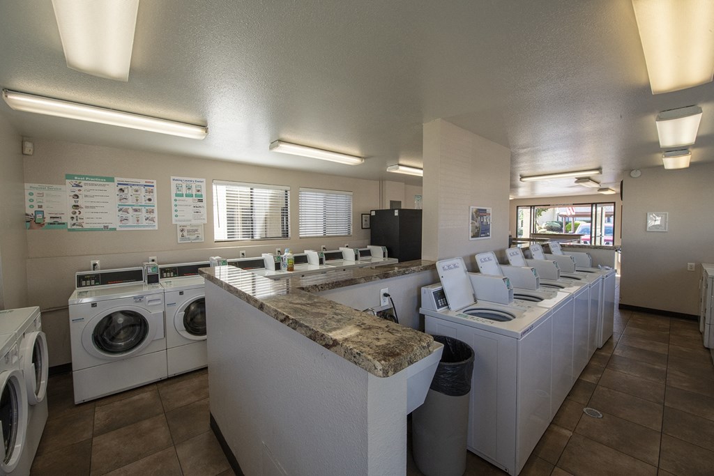 a laundry room with washers and dryers and a counter with washing machines at Sycamore Hills Village Apartments, Vista, California