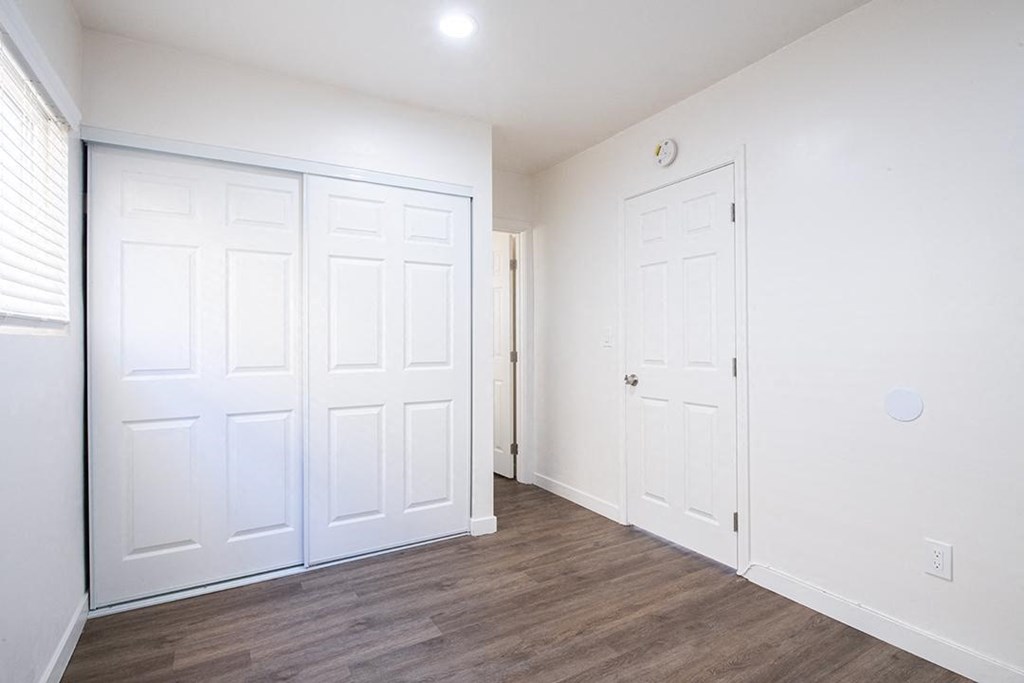 a bedroom with two closets and a door at Villa Primavera Apartments, California, 91950
