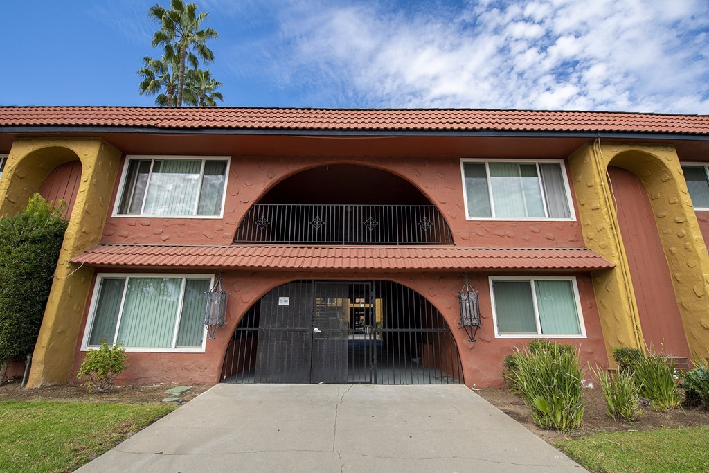 the front of a red and yellow house with a garage door at Villa Quixote Apartments, Escondido, CA