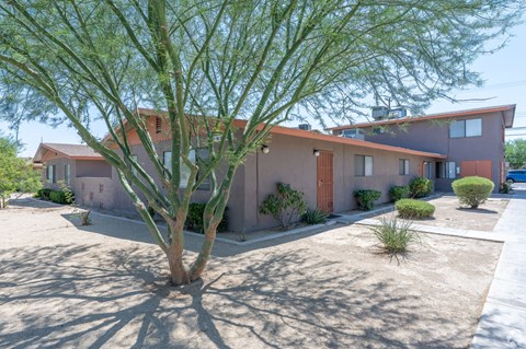 A house with a red roof and a tree in front.