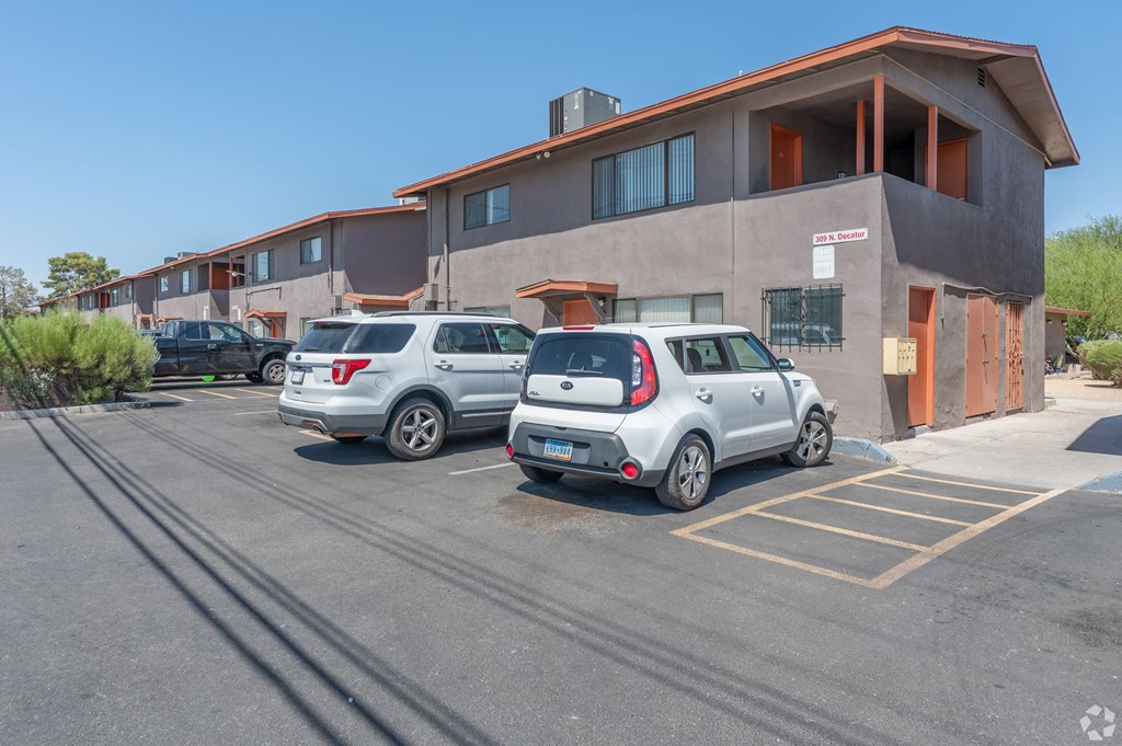 A parking lot with cars and a building in the background.