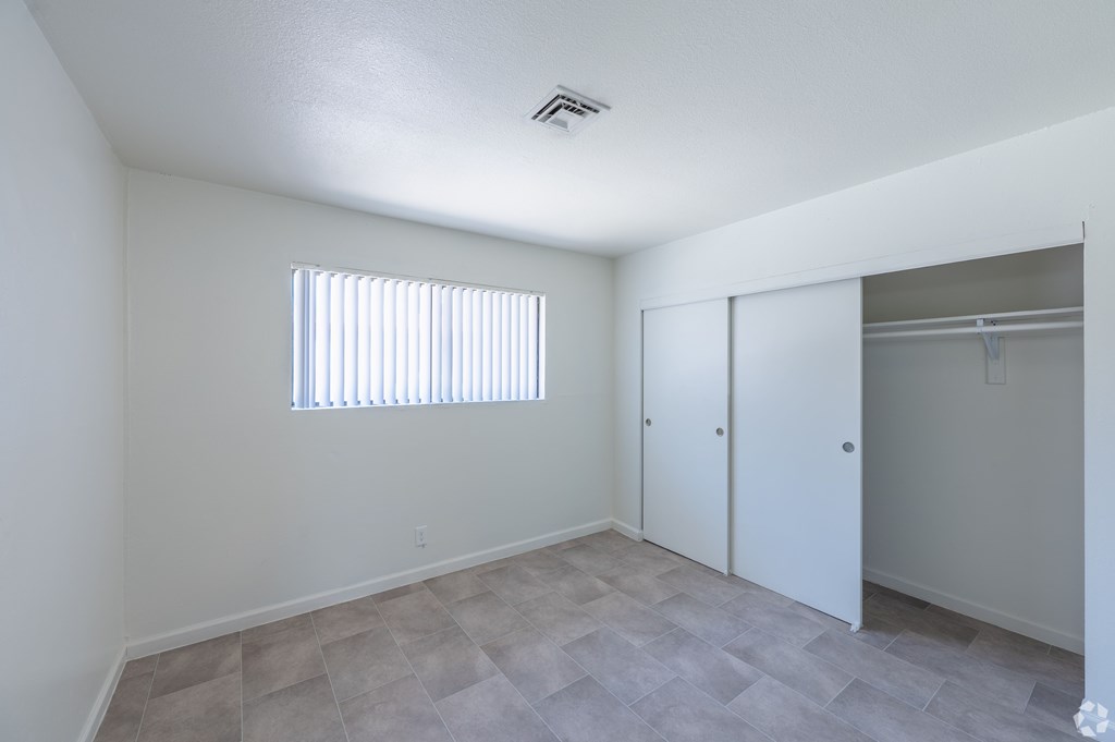 Bedroom with window and closet with sliding door.