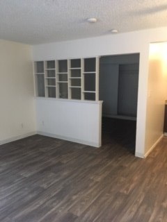 an empty living room with a hard wood floor and a window