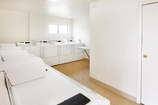 an empty kitchen with white appliances and white counter tops
