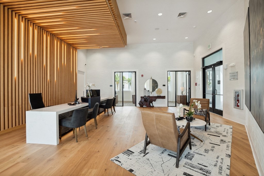 the living room and dining area of a modern home with wood floors and white walls