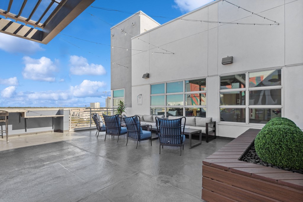 a patio with a table and chairs in front of a building
