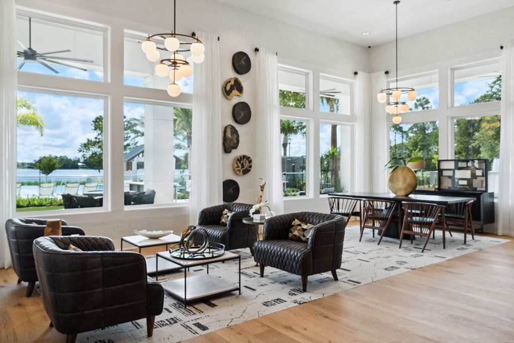 a living room with large windows and a table and chairs