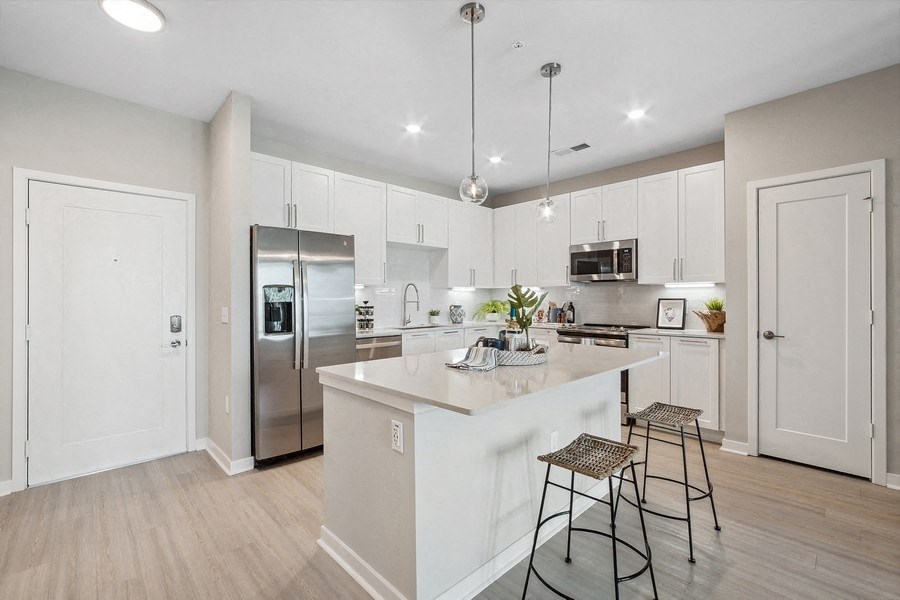 an open kitchen with a large island with two stools