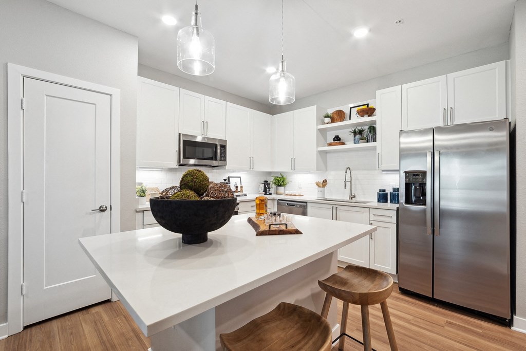 an open kitchen with a large island with a bowl of fruit