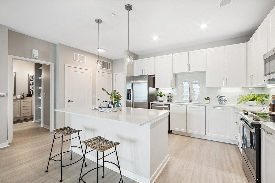 an open kitchen with a large island with two stools