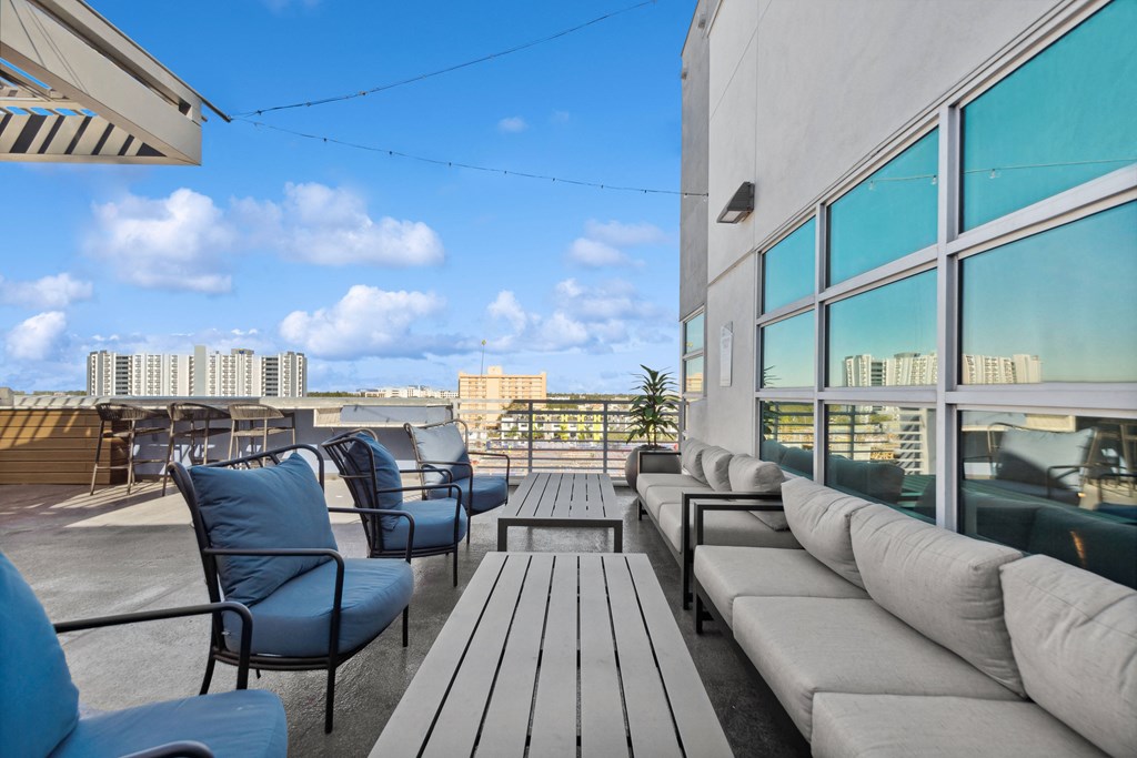 a rooftop patio with couches and chairs and tables