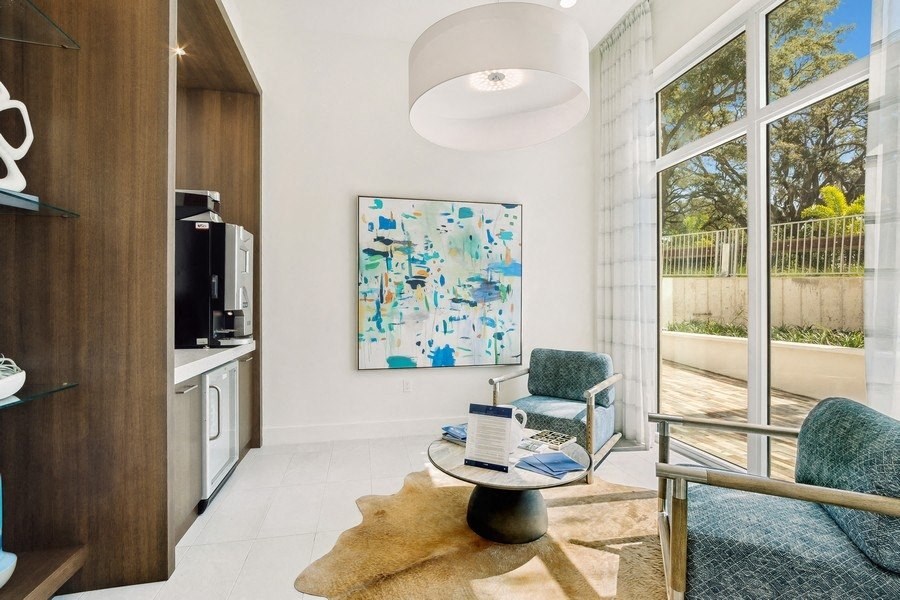 a living room with a chair and a table in front of a window