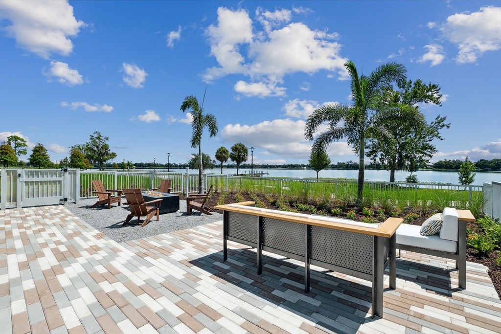 a patio with a table and chairs overlooking the water